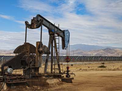 Lone pumpjack located in the middle of large solar array outside of Bakersfield