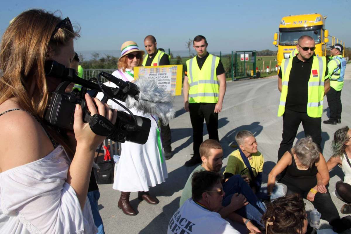 Protesters sit at the entrance of a fracking site in Lancashire to prevent work from progressing.