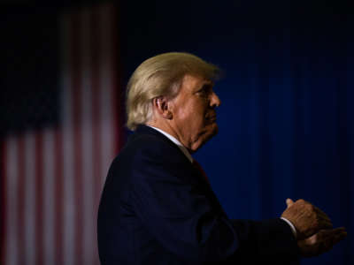 Former President Donald Trump claps during a rally on October 1, 2022, in Warren, Michigan.