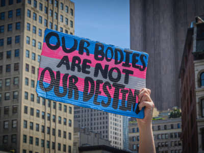 A protester holds a sign reading "OUR BODIES ARE NOT OUR DESTINIES" during a protest