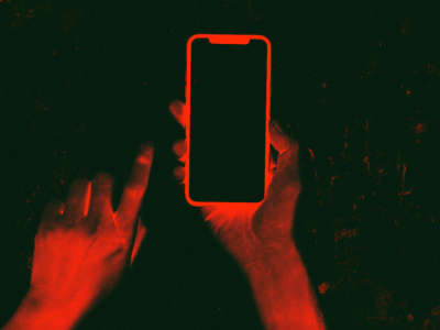 Inverted photo with red hands holding phone