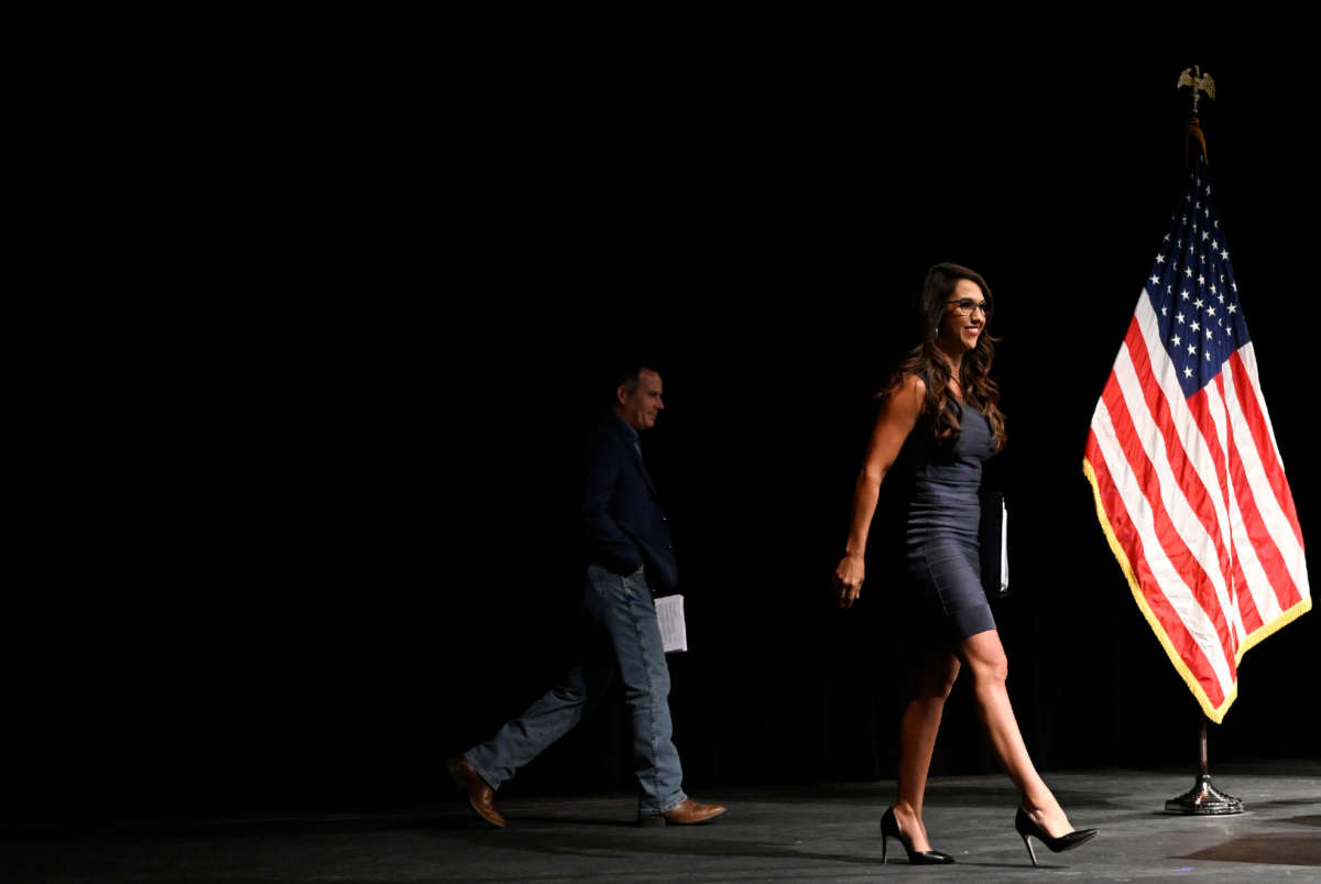 Democratic House Candidate Adam Frisch, left, still in the shadows, walks out on stage with incumbent Congresswoman Lauren Boebert for The Club 20 political conference debate at Colorado Mesa University on September 10, 2022, in Grand Junction, Colorado.