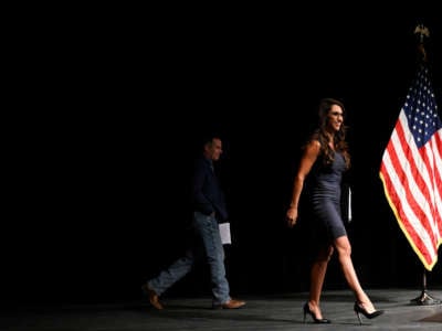 Democratic House Candidate Adam Frisch, left, still in the shadows, walks out on stage with incumbent Congresswoman Lauren Boebert for The Club 20 political conference debate at Colorado Mesa University on September 10, 2022, in Grand Junction, Colorado.