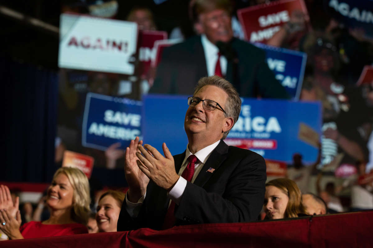 Republican candidate for Attorney General Matthew DePerno claps during former President Donald Trump's remarks during a Save America rally on October 1, 2022, in Warren, Michigan.