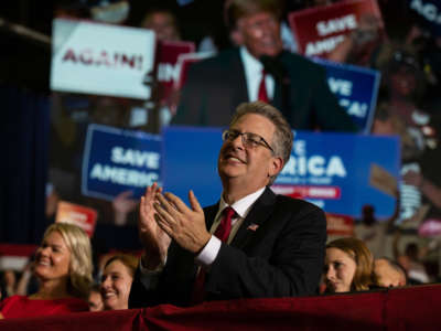 Republican candidate for Attorney General Matthew DePerno claps during former President Donald Trump's remarks during a Save America rally on October 1, 2022, in Warren, Michigan.