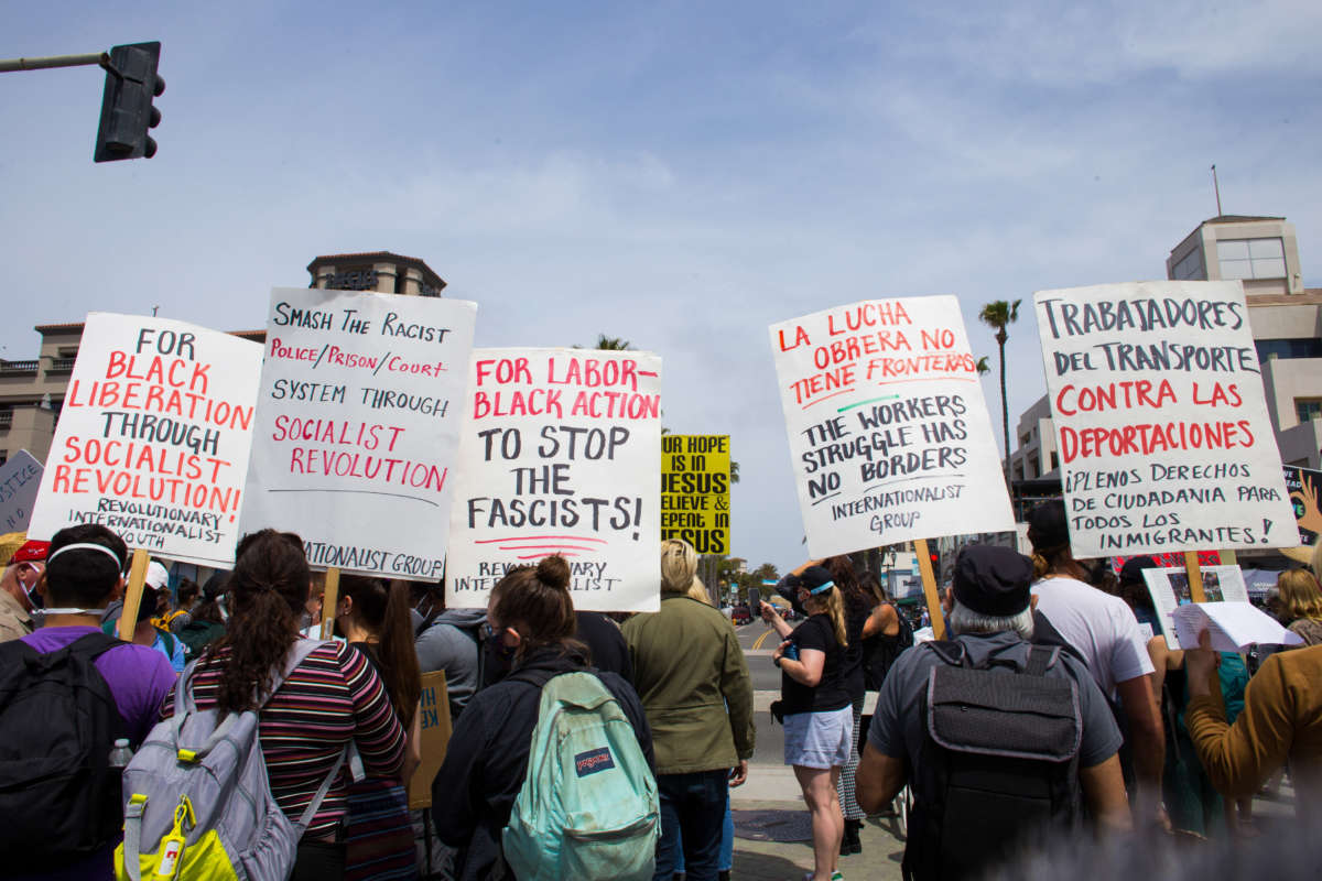 People holding placards counter-protest against a White Lives Matter demonstration in Huntington Beach, California, on April 11, 2021.