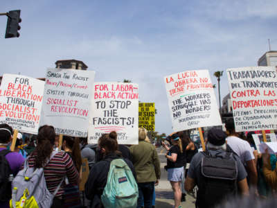 People holding placards counter-protest against a White Lives Matter demonstration in Huntington Beach, California, on April 11, 2021.