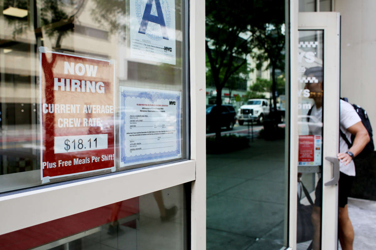 A 'Now Hiring' sign is displayed on a shopfront on August 5, 2022, in New York City.