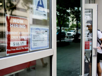 A 'Now Hiring' sign is displayed on a shopfront on August 5, 2022, in New York City.