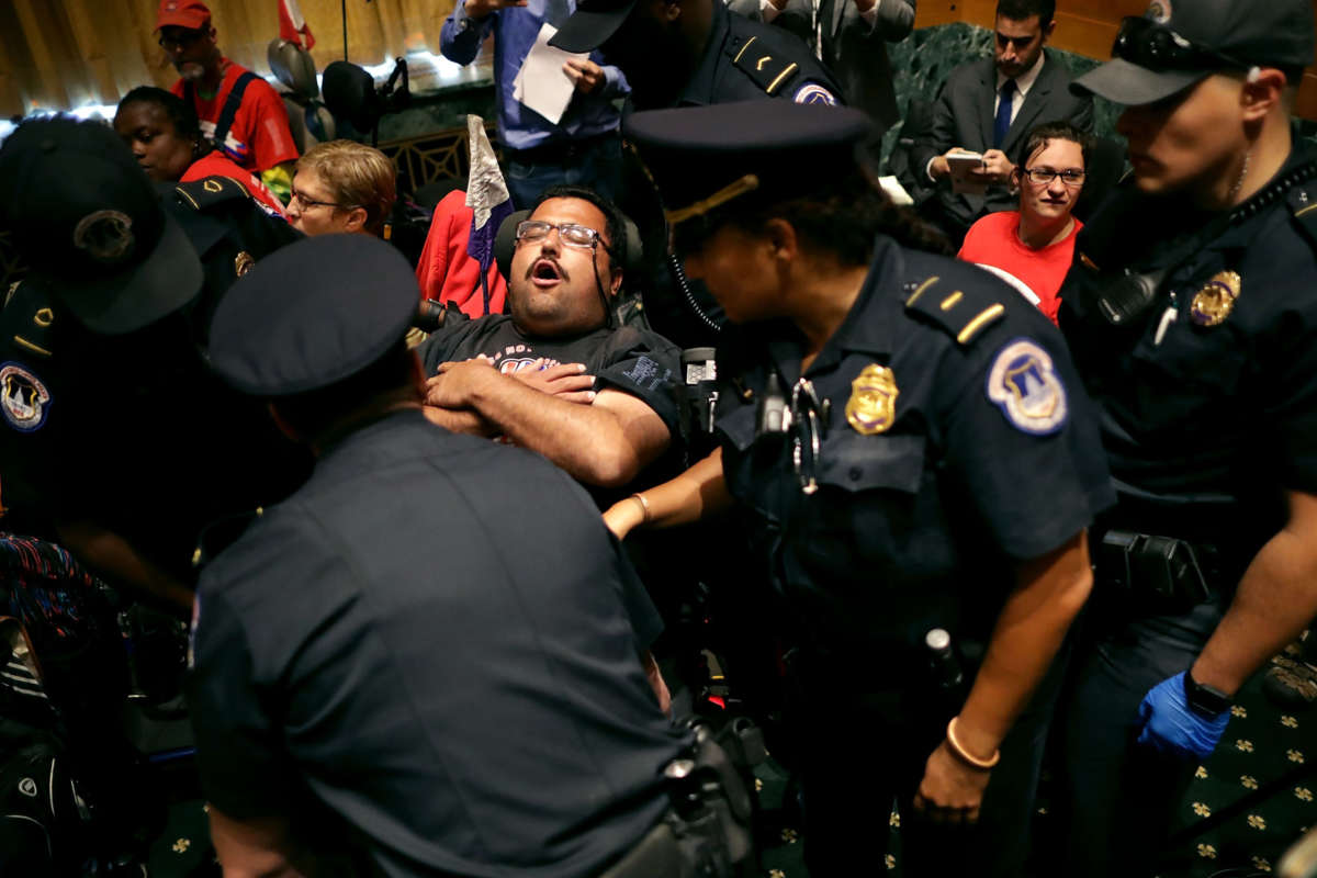 U.S. Capitol Police arrest demonstrators from disability advocacy organizations as they interrupt a Senate Finance Committee hearing on a bill proposed to repeal the Affordable Care Act, in the Dirksen Senate Office Building on Capitol Hill on September 25, 2017, in Washington, D.C.
