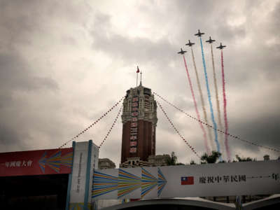 Trainer jets from the Republic of China Air Force fly over Taipei's Presidential Office Building while letting out colored smoke of Taiwan's flag.