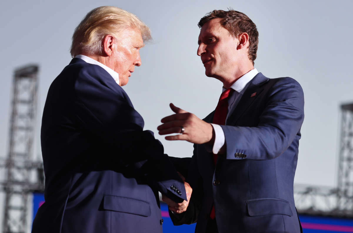 Former President Donald Trump, left, shakes hands with Republican Senate candidate Blake Masters at a campaign rally at Legacy Sports USA on October 9, 2022, in Mesa, Arizona.