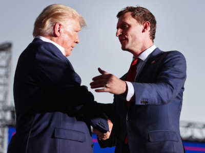 Former President Donald Trump, left, shakes hands with Republican Senate candidate Blake Masters at a campaign rally at Legacy Sports USA on October 9, 2022, in Mesa, Arizona.