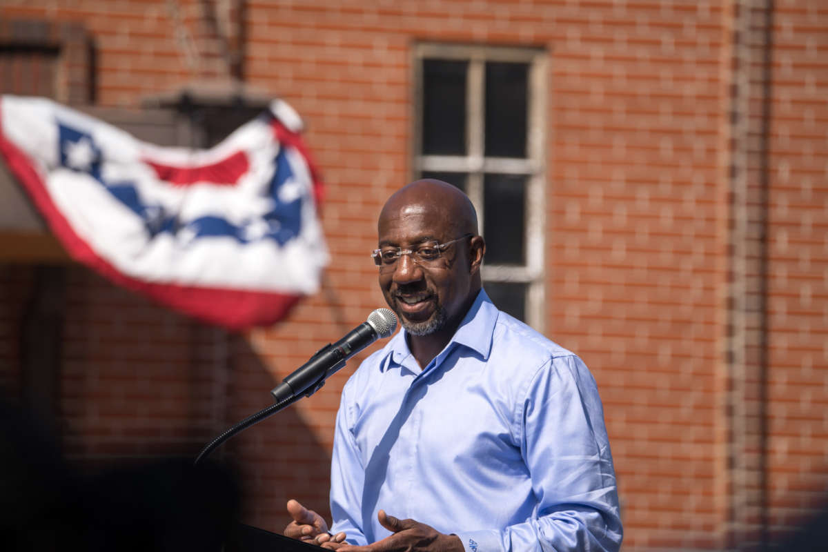 Sen. Raphael Warnock speaks to supporters during his campaign tour, outside of the Liberty Theater on October 8, 2022, in Columbus, Georgia.