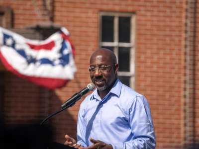 Sen. Raphael Warnock speaks to supporters during his campaign tour, outside of the Liberty Theater on October 8, 2022, in Columbus, Georgia.