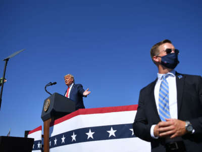 A U.S. secret service agent stands guard as then-President Donald Trump speaks during a rally at Prescott Regional Airport in Prescott, Arizona, on October 19, 2020.