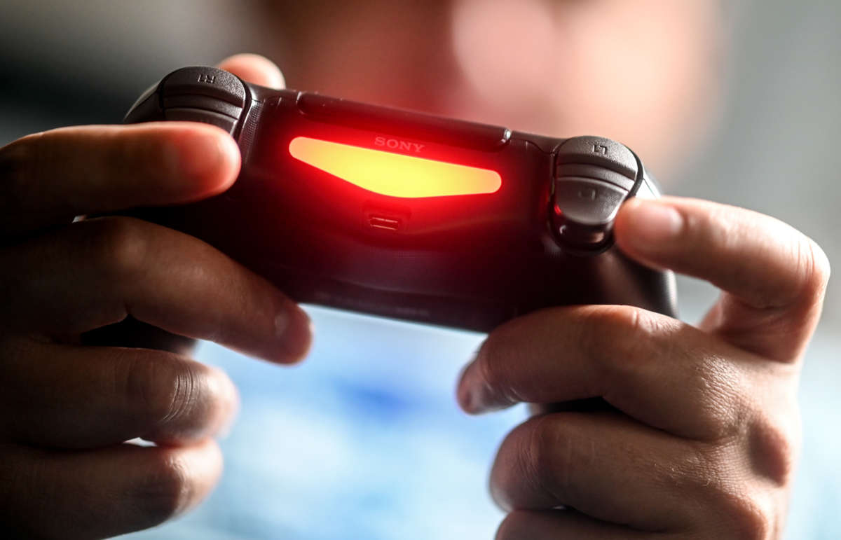 A young man plays with a Playstation 4 game console in Berlin, Germany, on April 2, 2020.