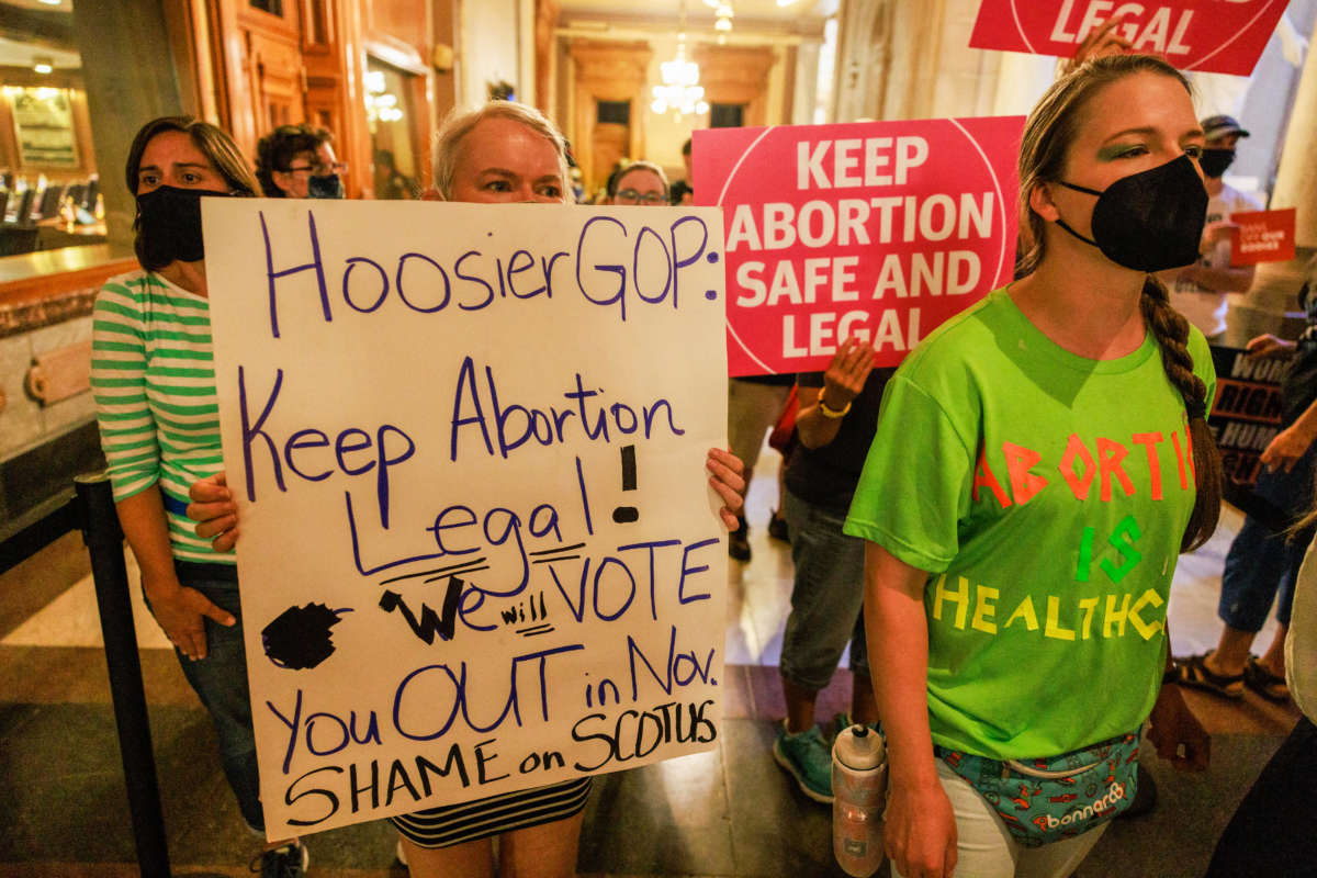 Abortion rights activists hold signs inside the Indiana State house during a special session in Indianapolis, Indiana, on August 5, 2022.