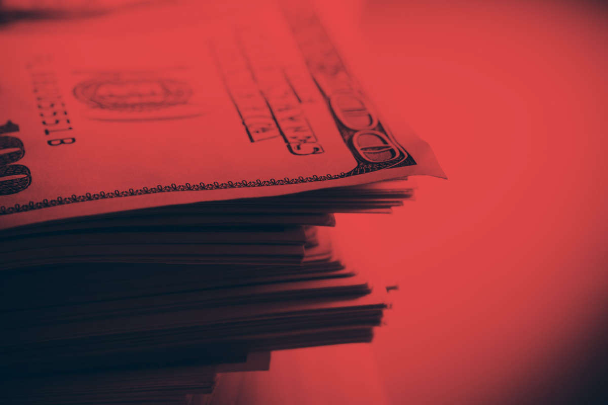 Stack of hundred dollar bills with red overlay