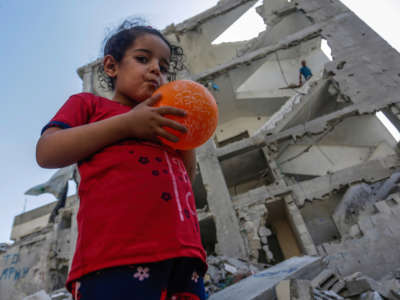A Palestinian girl stands on the ruins of their destroyed house in the city of Rafah in the southern Gaza Strip on August 16, 2022.