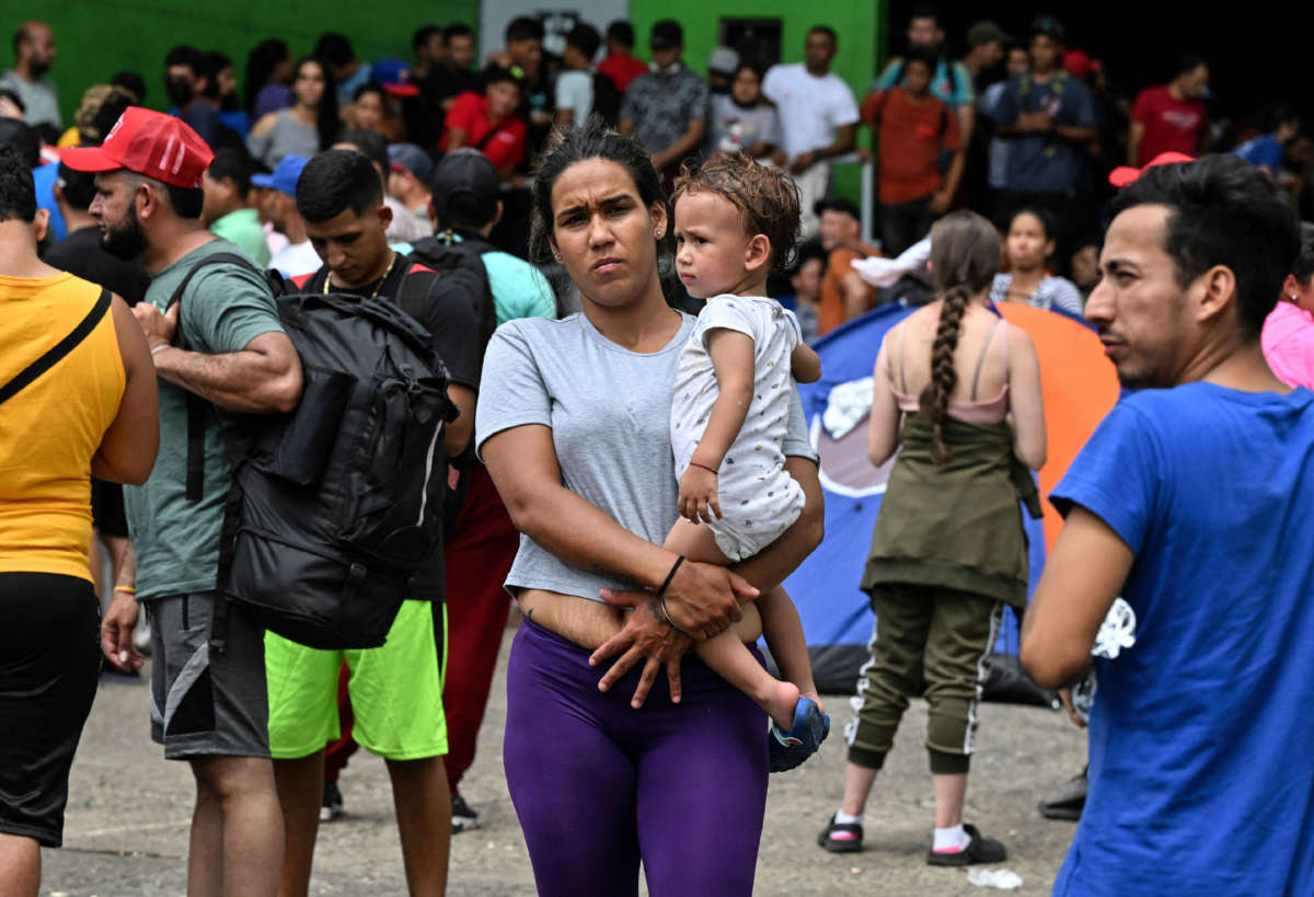 A Venezuelan migrant holds a child in her arms upon arriving at an improvised shelter in Panama City, on October 23, 2022.