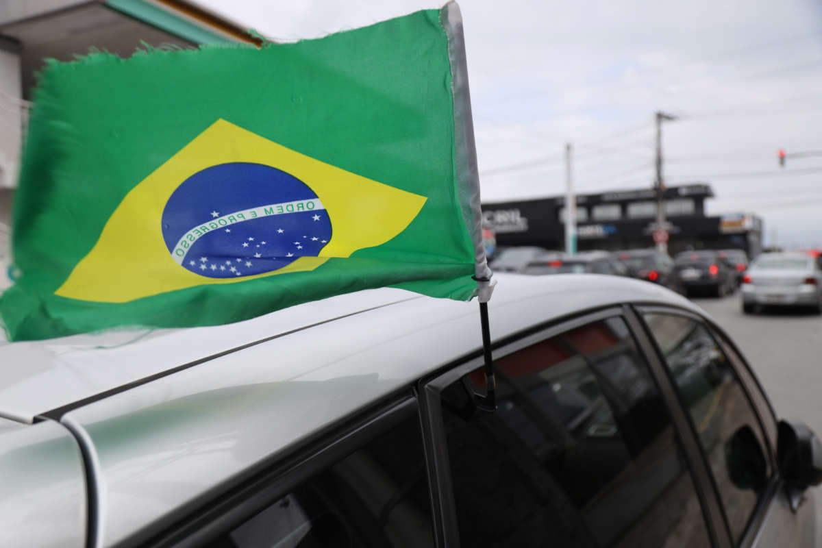 A Brazilian flag sticks out of a car window outside of a rally for Bolsonaro in Florianopolis, Brazil, in late October.