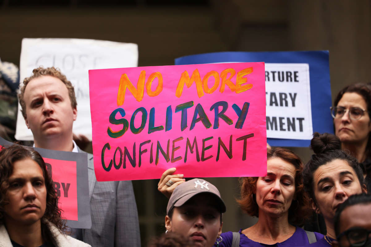 People hold signs calling for an end to solitary confinement at a rally on October 25, 2022 in New York City.