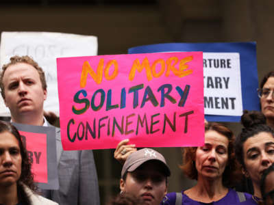 People hold signs calling for an end to solitary confinement at a rally on October 25, 2022 in New York City.