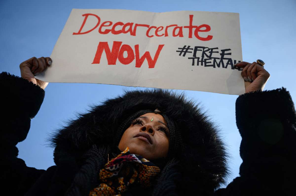 Protestor holds "Decarcerate Now" sign