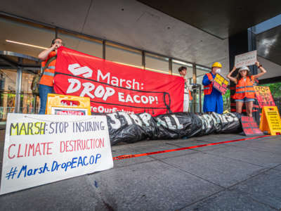Activists rally outside the headquarters of insurance company Marsh McLennan in New York City, urging CEO Dan Glaser to cut ties with the East African Crude Oil Pipeline (EACOP) on July 1, 2022.