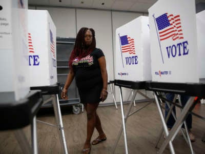 A volunteer election worker assembles voting booths at the Robert L. Gilder Elections Service Center on August 5, 2022 in Tampa, Florida.