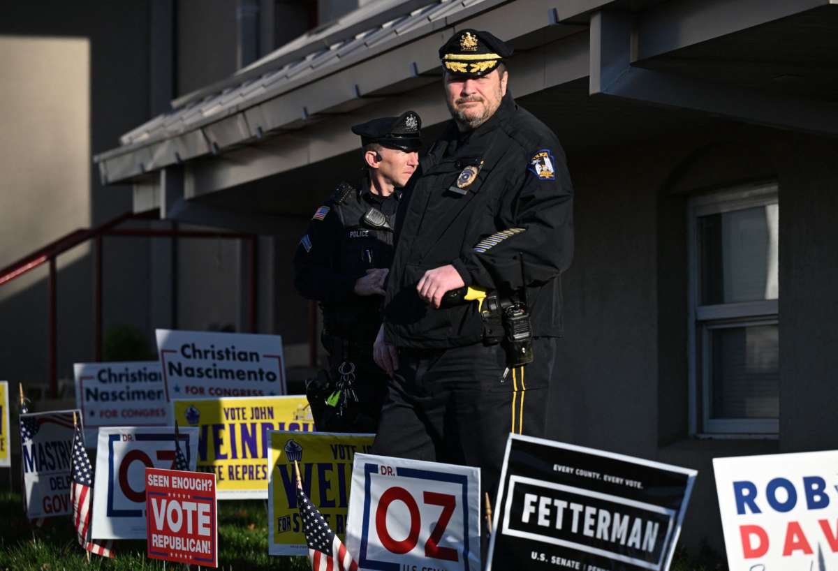 Police are shown standing amid campaign signs during the US midterm election at a polling station in Bryn Athyn, Pennsylvania, on November 8, 2022.