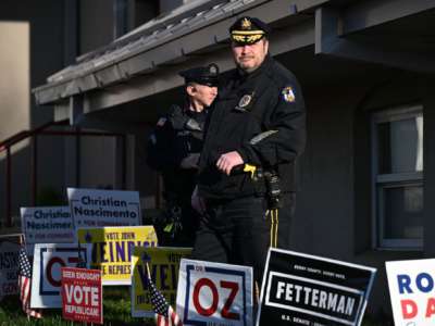 Police are shown standing amid campaign signs during the US midterm election at a polling station in Bryn Athyn, Pennsylvania, on November 8, 2022.