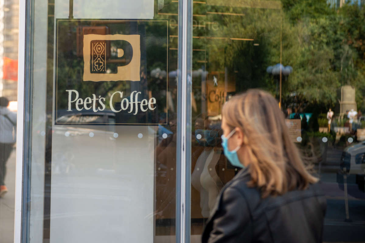 A woman wearing a mask walks past a Peet's Coffee in Union Square on September 30, 2020 in New York City.