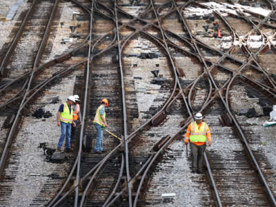 Workers service the tracks at the Metra/BNSF railroad yard outside of downtown on September 13, 2022 in Chicago, Illinois.