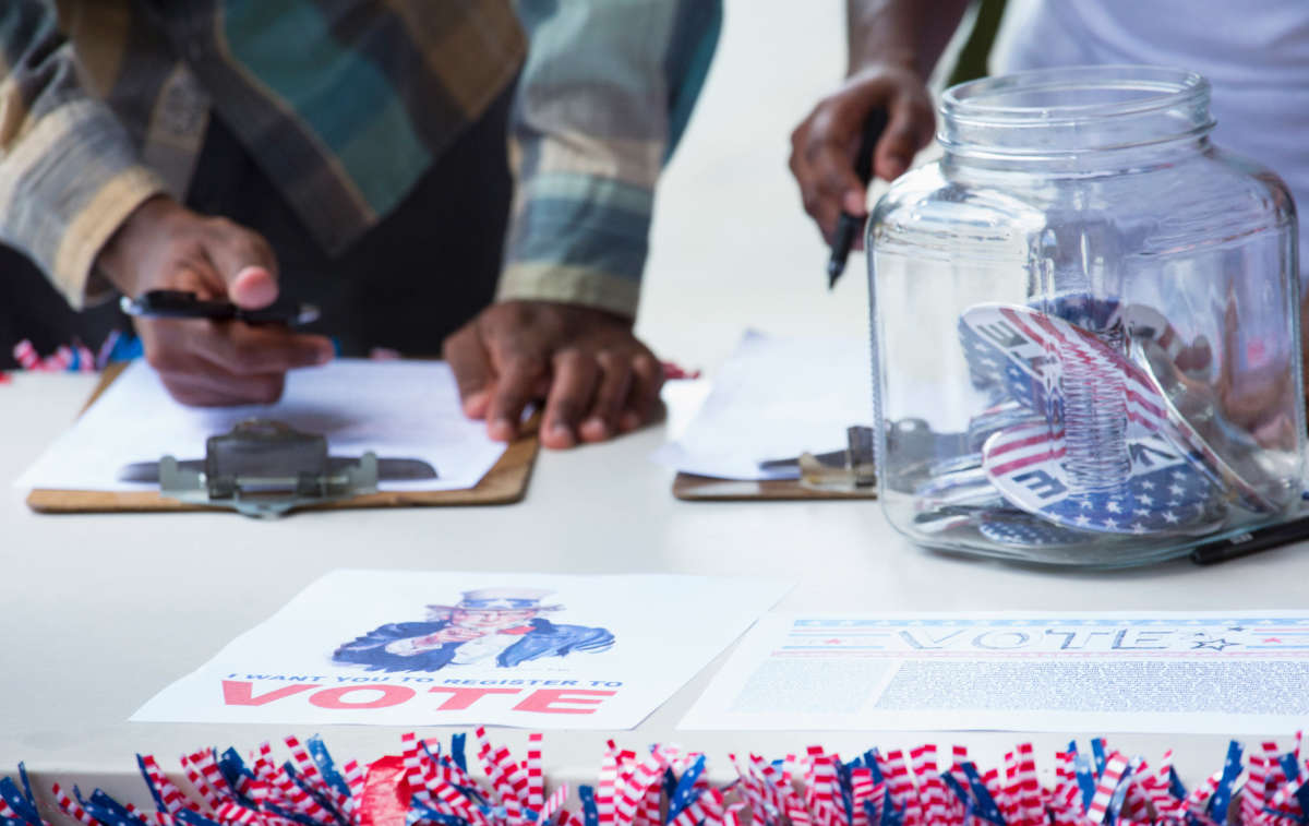 View of hands of people registering to vote