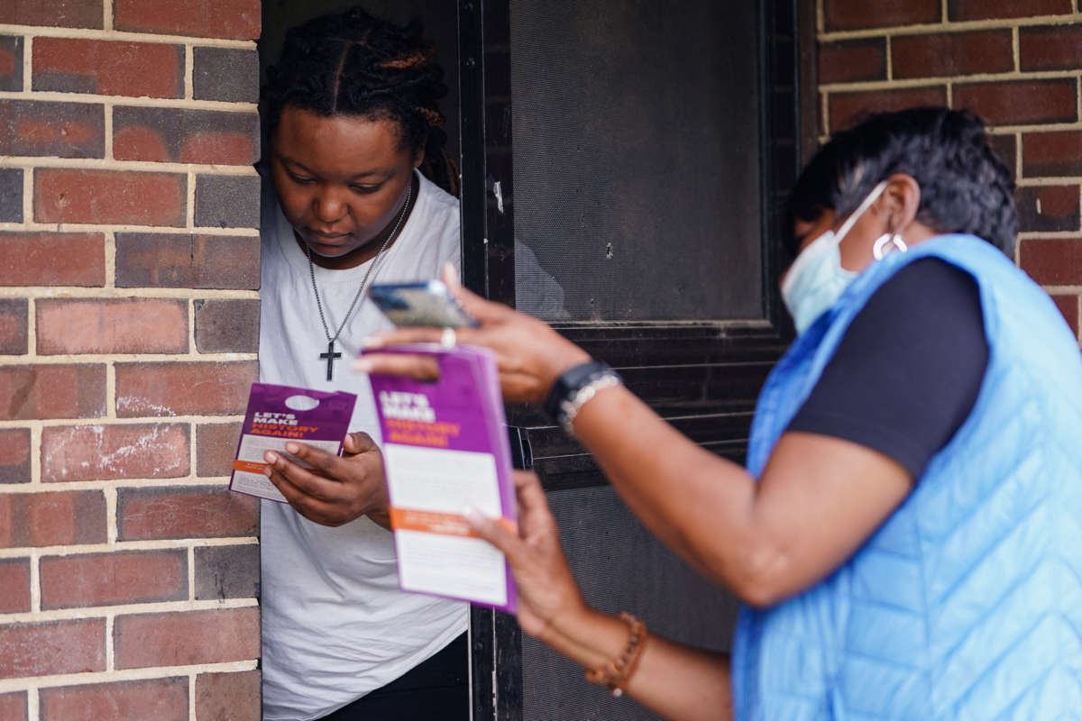 A canvasser speaks to a resident at her front door