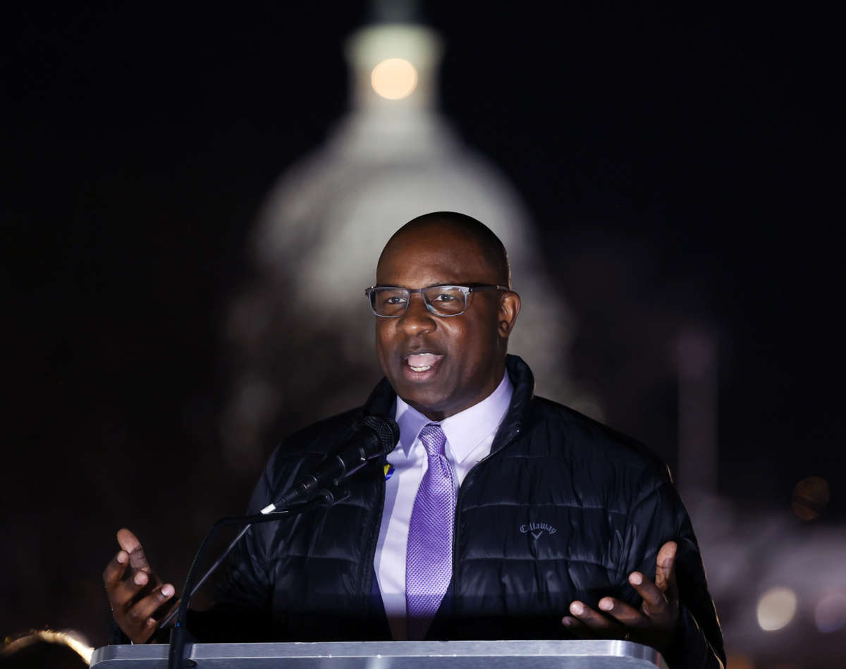 Jamaal Bowman speaks at a podium during an outdoor evening event