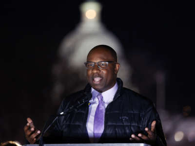 Jamaal Bowman speaks at a podium during an outdoor evening event