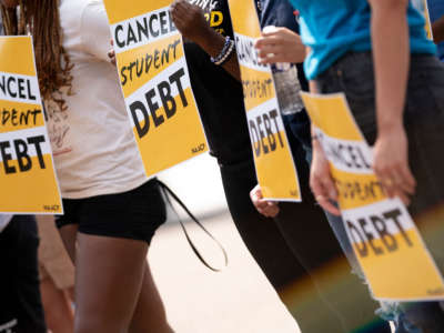 Activists hold cancel student debt signs as they gather to rally in front of the White House in Washington, D.C., on August 25, 2022.