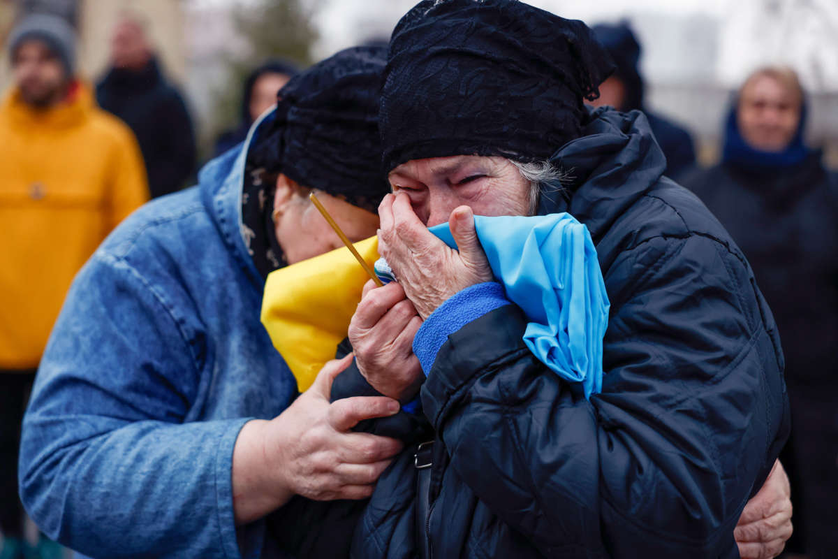 A woman cries into the Ukrainian flag