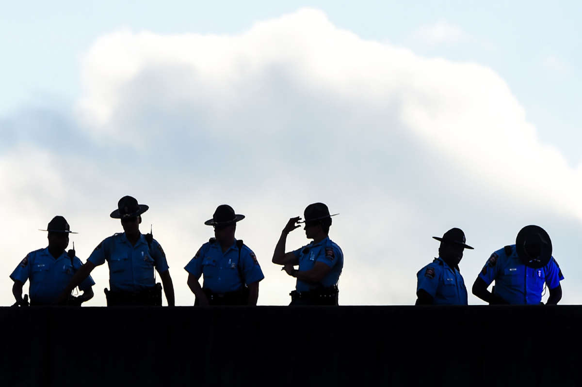 Police stand guard on a bridge as protestors block the road on the fourth day of protests following Rayshard Brooks's shooting death by police, on June 16, 2020, in Atlanta, Georgia.