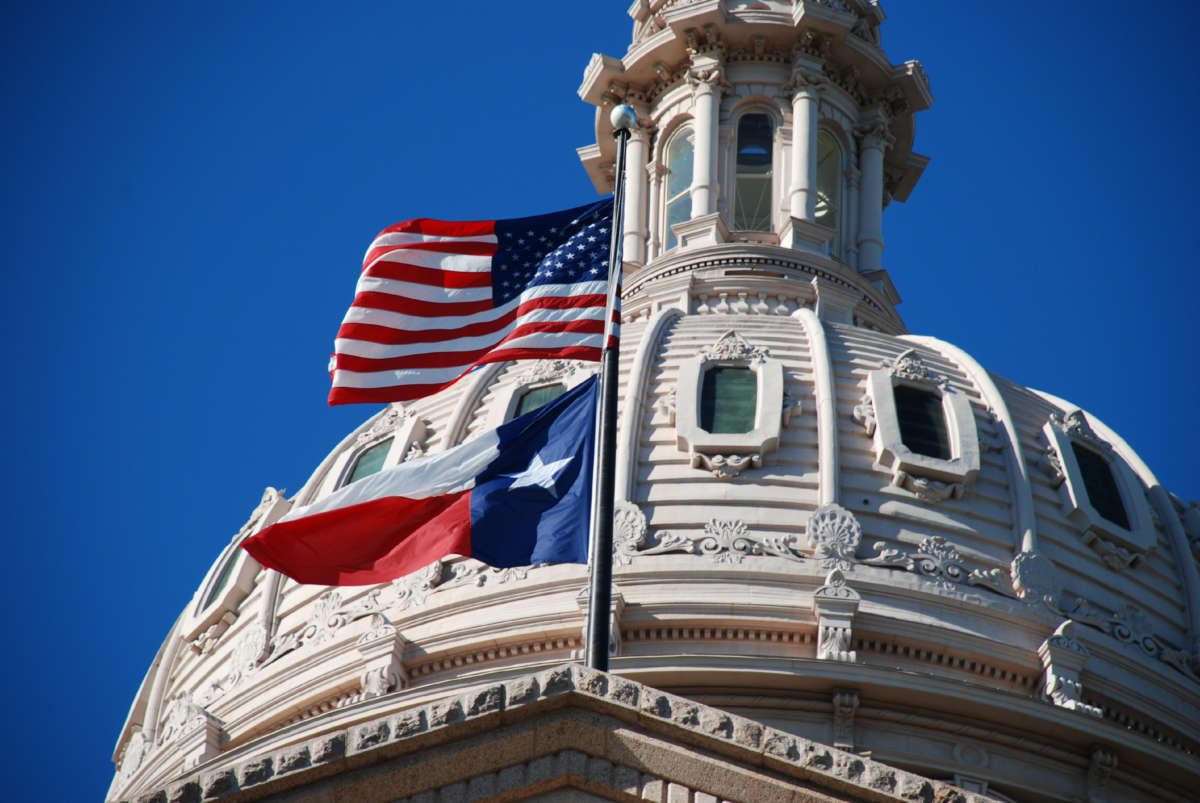 USA and Texas flags wave at the Texas state capitol in Austin, Texas.