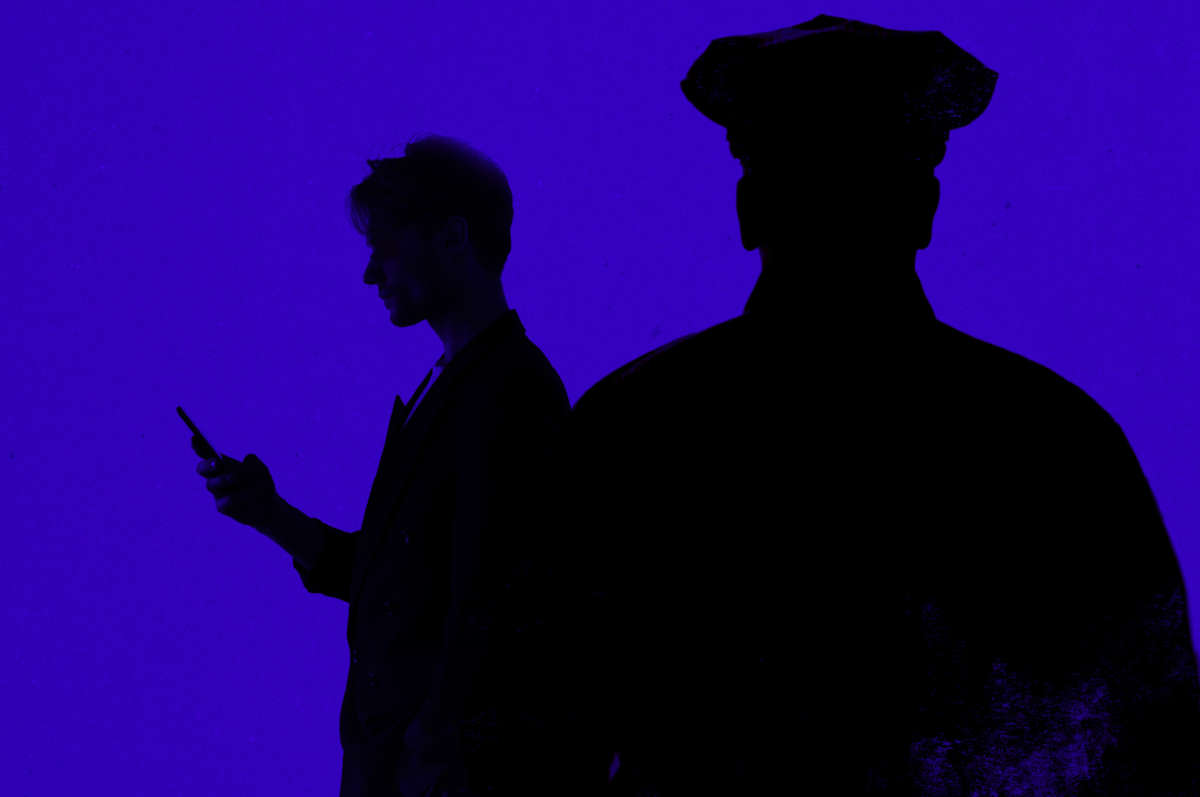 Silhouettes of person checking phone and police officer watching in foreground