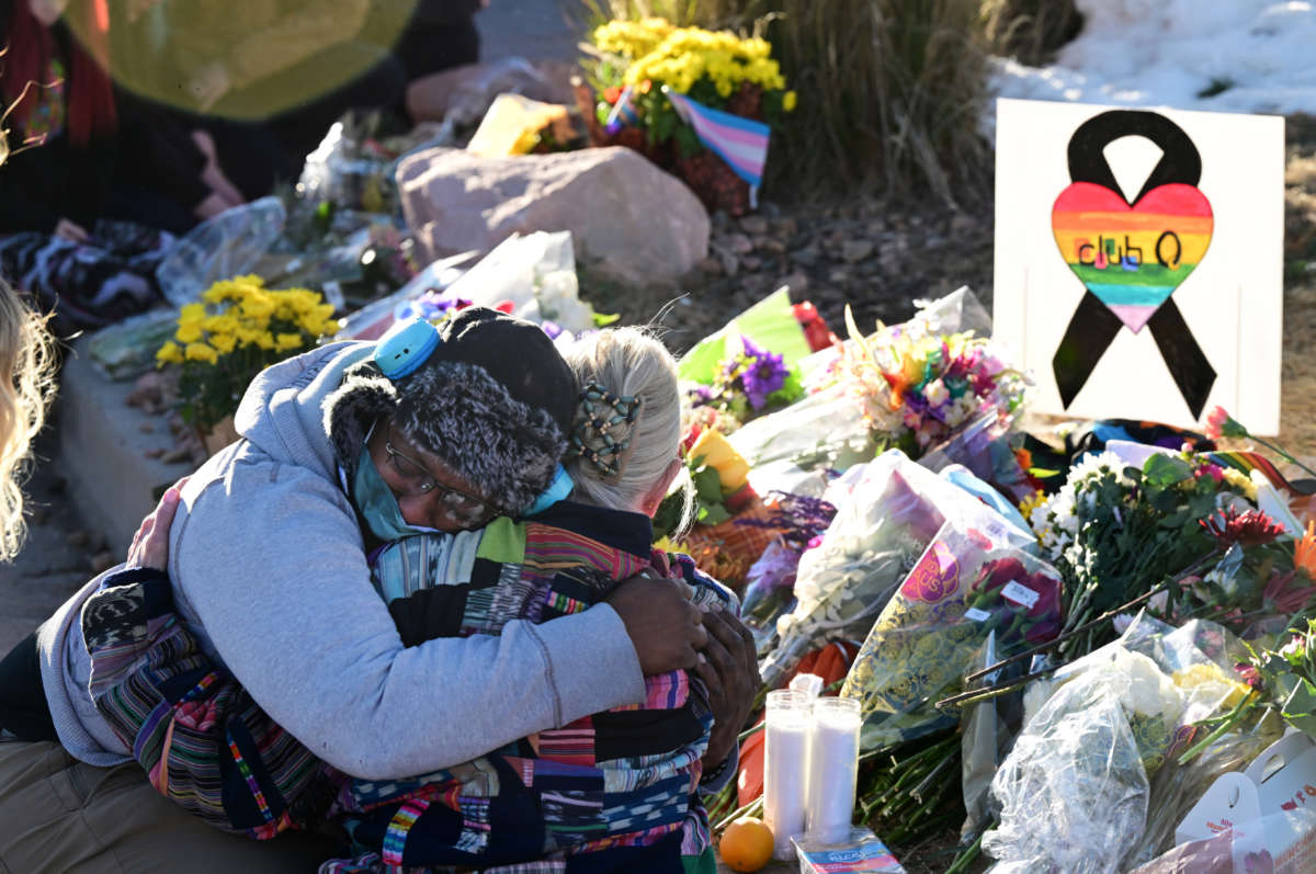 Justice Lord gets comforted by a friend at a makeshift memorial near Club Q on November 20, 2022, in Colorado Springs, Colorado.