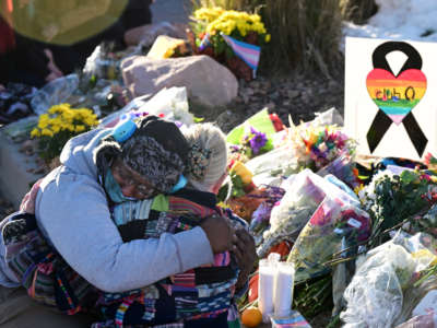 Justice Lord gets comforted by a friend at a makeshift memorial near Club Q on November 20, 2022, in Colorado Springs, Colorado.