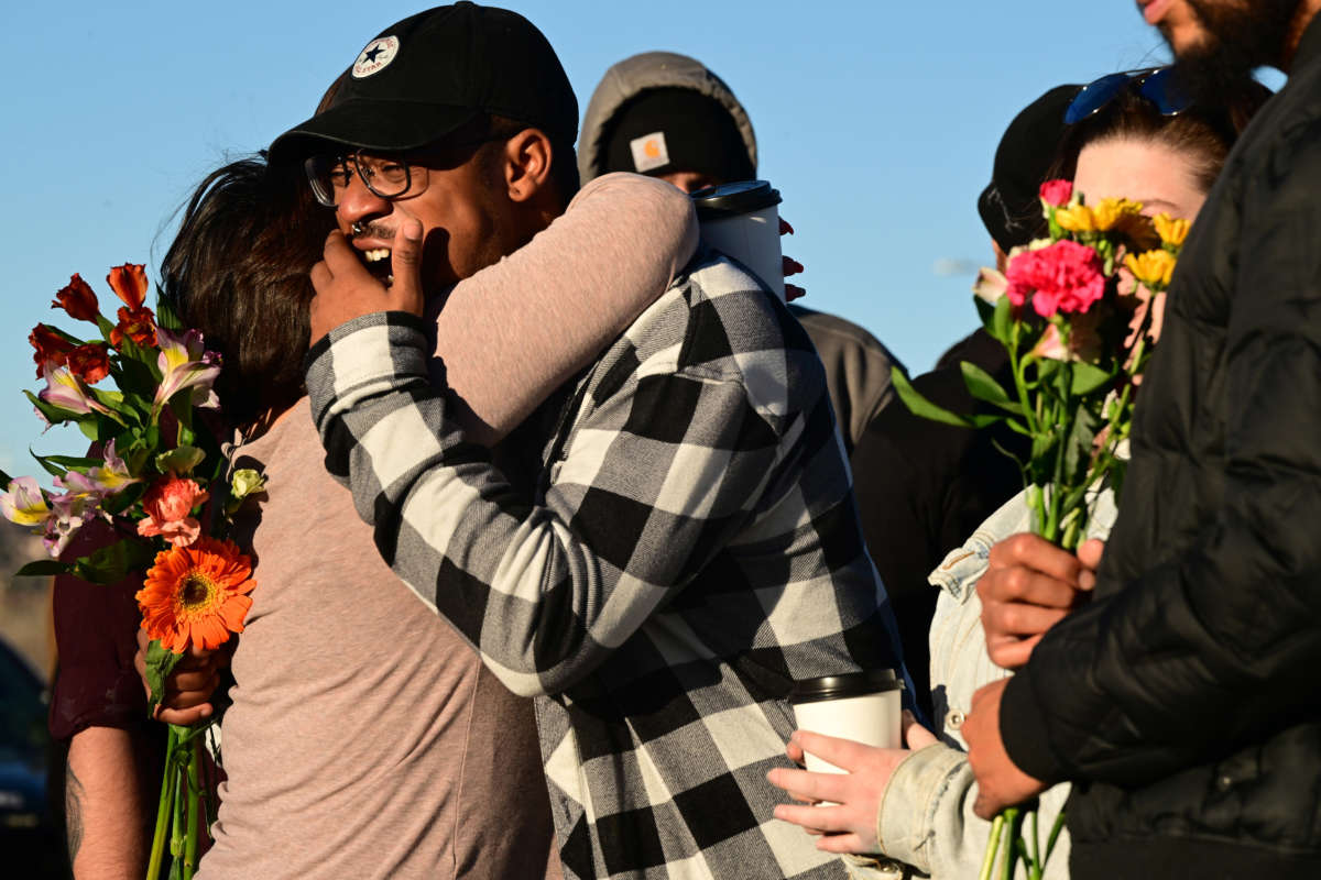 Jezeravon Swisher, center, gets comforted by friends at a makeshift memorial near Club Q on November 20, 2022, in Colorado Springs, Colorado.