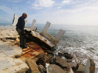 Ruperto Chaparro, director of Puerto Rico Sea Grant, shows the damage caused by beach erosion by 2017's hurricanes, in Rincón, Puerto Rico, on September 5, 2018.