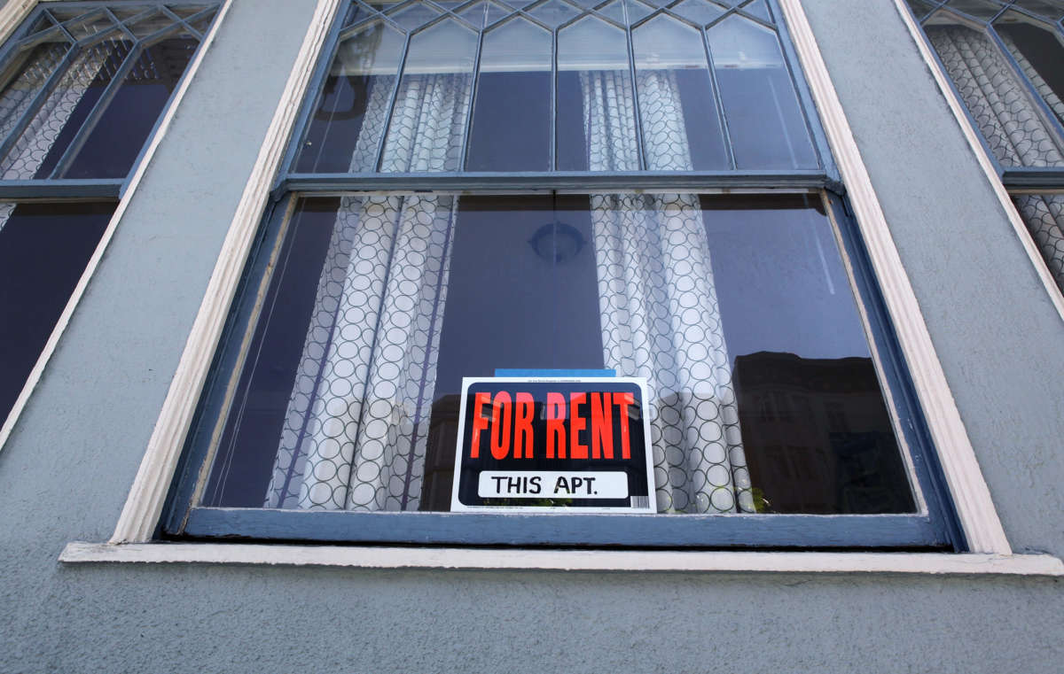 the exterior of a building with "for rent" sign on the front door