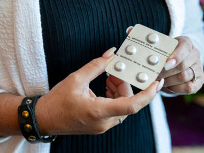 Melissa Grant, chief operating officer of Carafem, holds up pills used for abortion in Washington, D.C., on July 1, 2022.